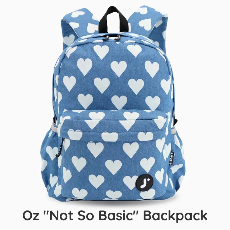 A blue backpack with a white heart pattern, shown against a light gray background with text at the bottom reading 'Oz "Not So Basic" Backpack'.