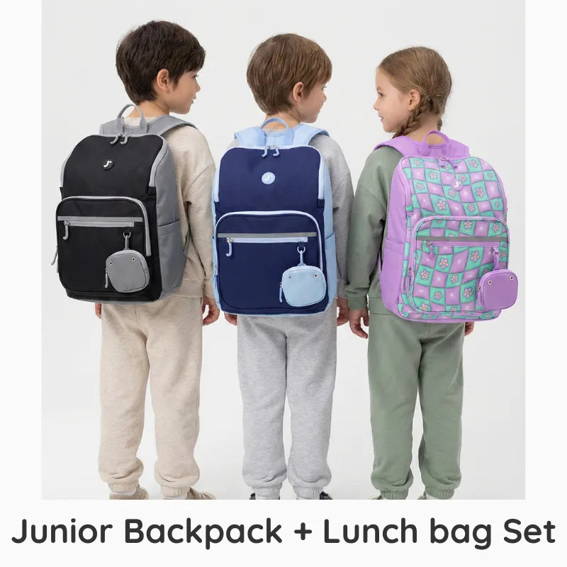 Three children wearing junior backpacks and lunch bags on a white background